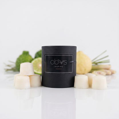 Black cylindrical container with 'obvs' branding on a white surface with decorative elements wax melts