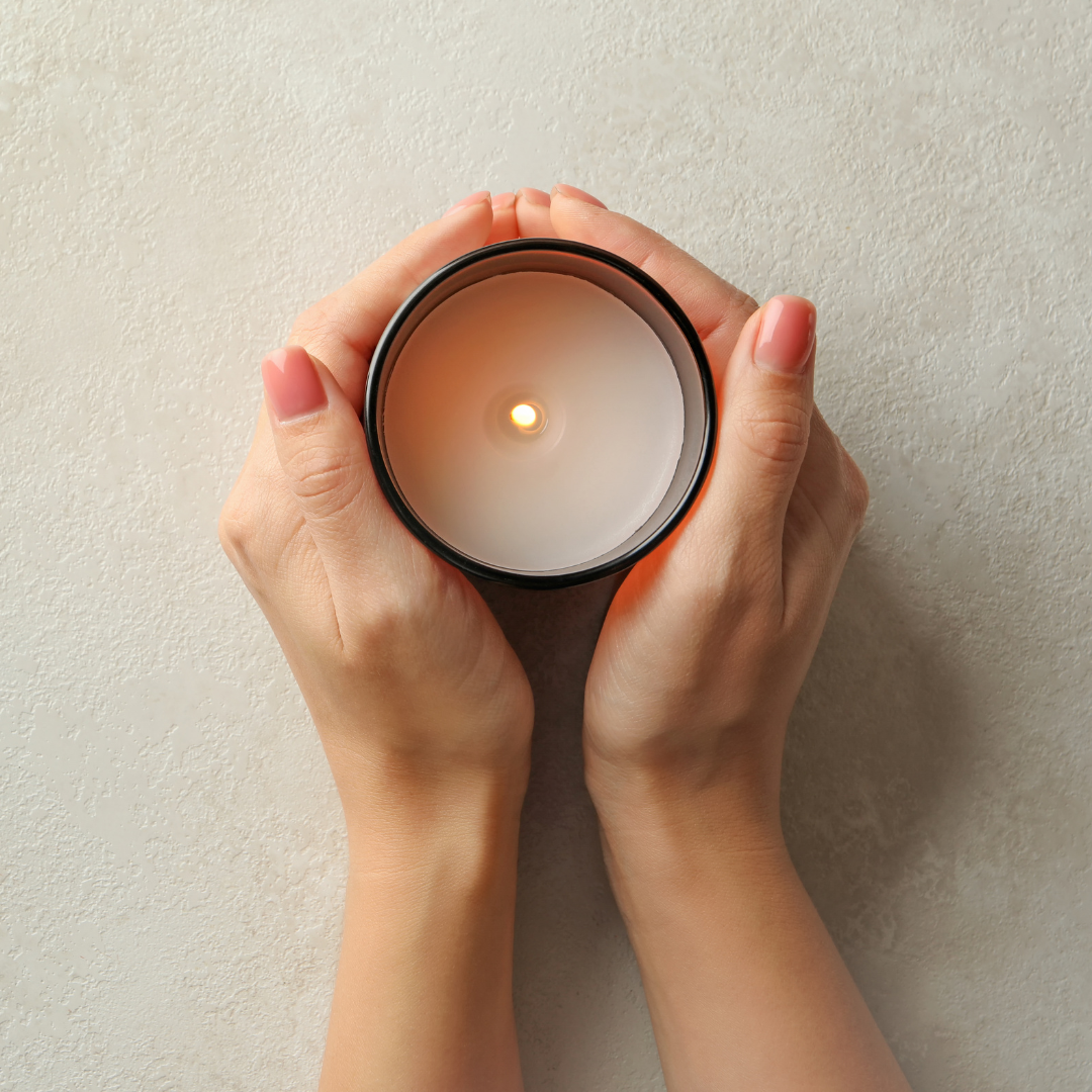 A matte black candle jar filled with organic essential oils, burning with a soft, warm flame. The minimalist design exudes elegance, while the gentle aroma from natural essential oils creates a calming, eco-friendly atmosphere. The candle sits on a wooden surface, with subtle shadows enhancing its luxurious, earthy vibe, perfect for relaxation or meditation