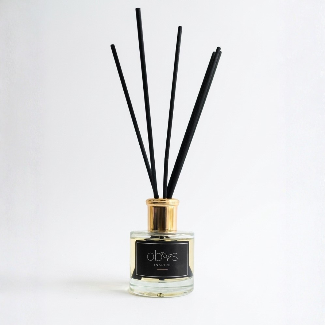 Reed diffuser with black sticks in a glass bottle on a white background
