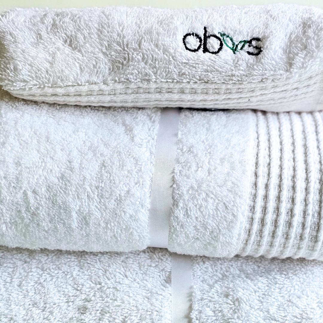 Indulge in the ultimate luxury with the Obvs at Home GOTS Certified Organic Towel Bundle. Crafted from the softest organic cotton, this collection—featuring a bath towel, hand towel, and Obvs face cloth—wraps you in pure, soothing comfort. The plush texture caresses your skin, elevating your daily ritual to an experience of serene indulgence. Eco-friendly and exquisitely soft, these towels are a true testament to sustainable luxury. Perfect for those who seek both indulgence and mindfulness in every moment.