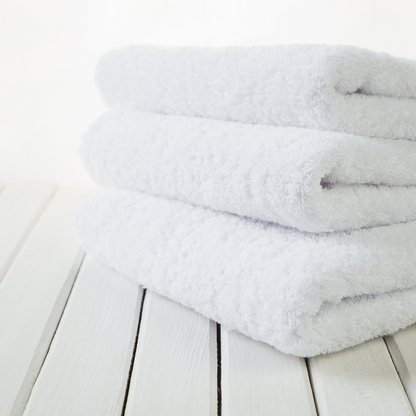 
A neatly folded organic cotton towel in a soft, natural shade, with a smooth, plush texture. The towel lies on a wooden surface, radiating a sense of warmth and luxury. Nearby, a hint of greenery adds a touch of nature, highlighting the towel’s eco-friendly, sustainable origins, perfect for a relaxing, spa-like self-care experience