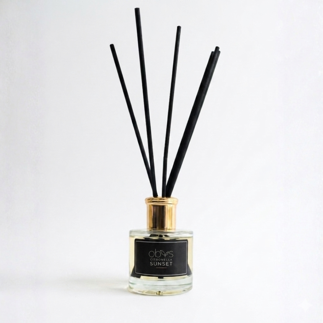 Reed diffuser with black sticks in a glass bottle on a white background