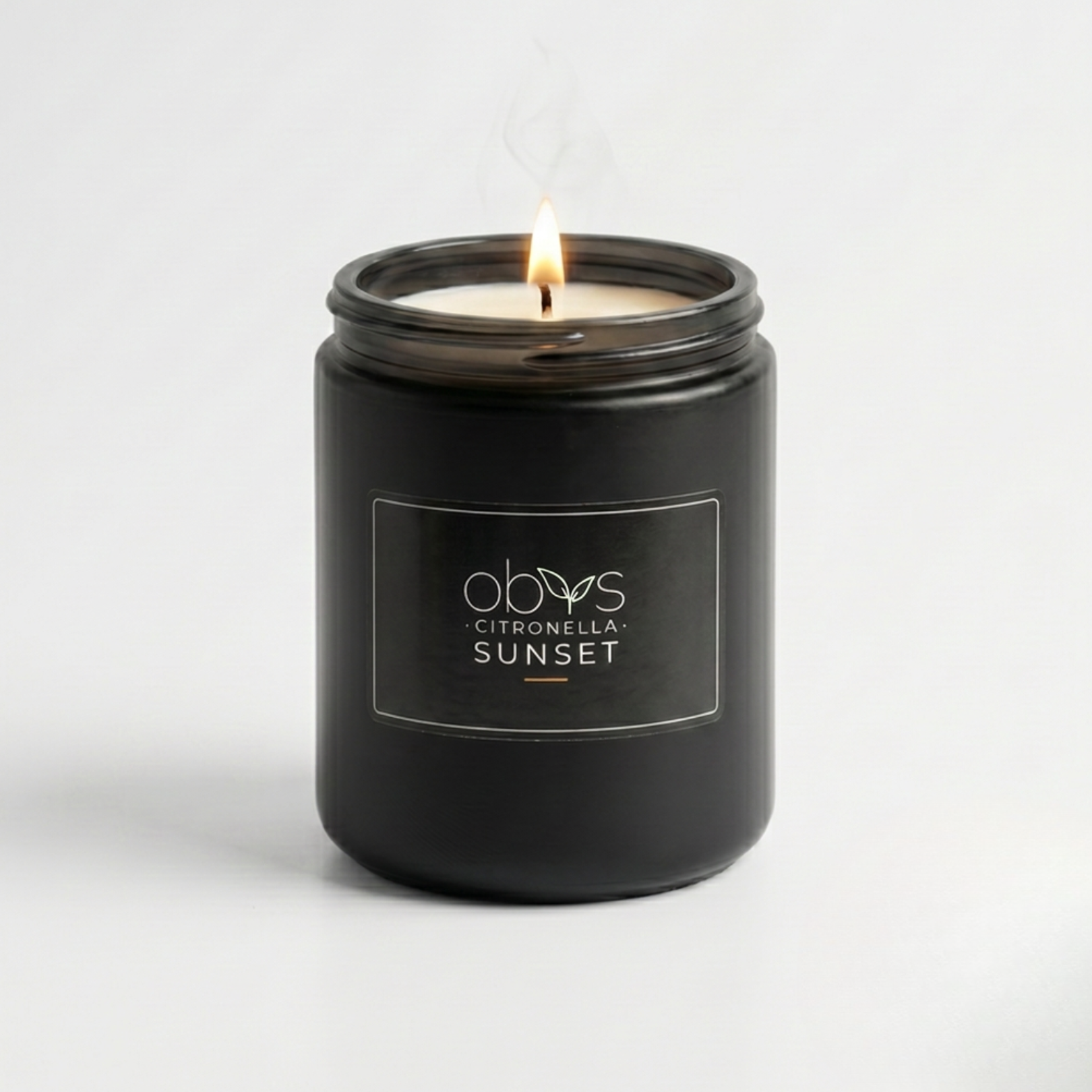 Black candle jar with a lit candle on a white background